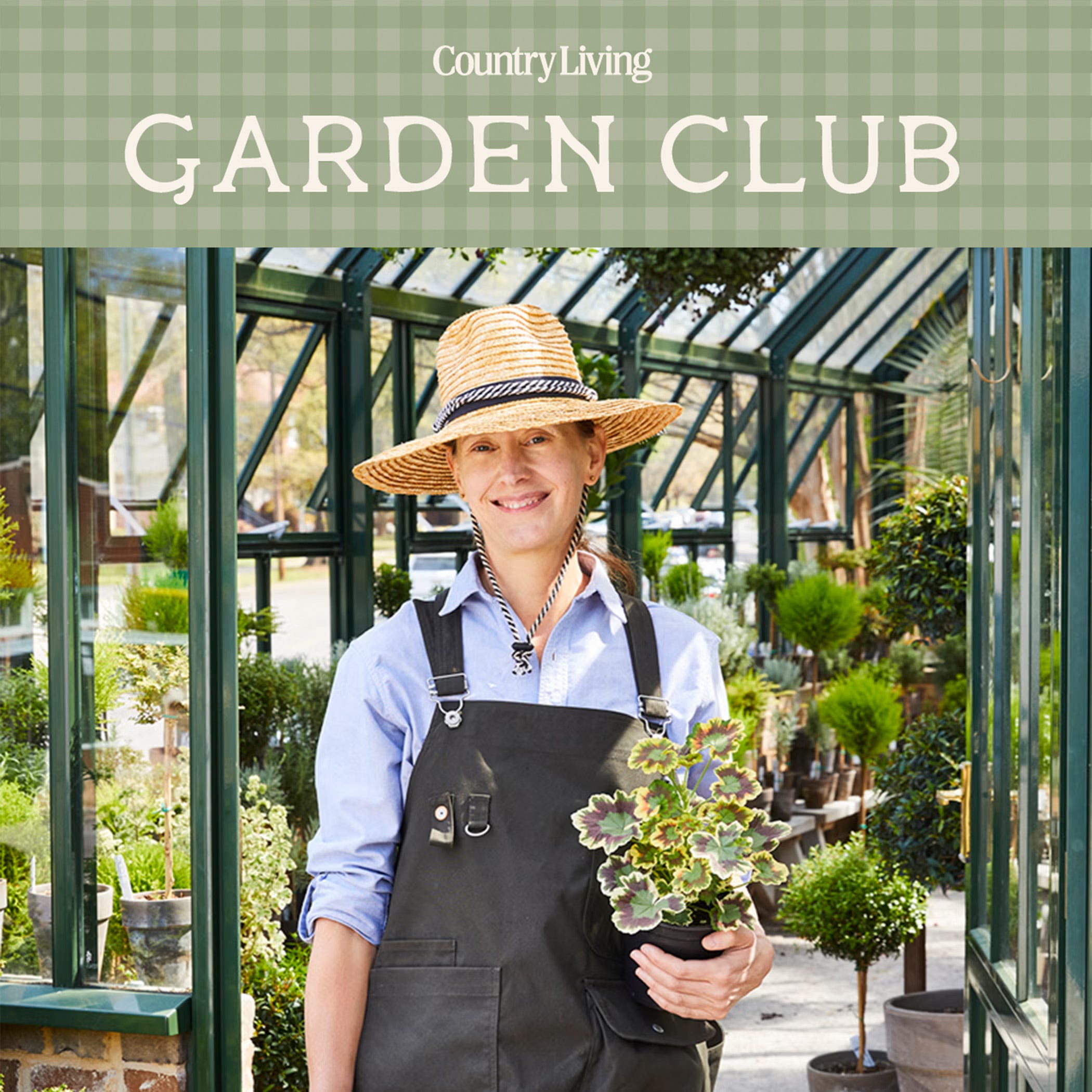 Charlyne Mattox wearing brimmed straw hat and garden apron, holding flowers and potted plants in a greenhouse